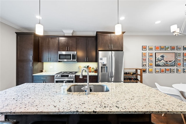 1343 W Clifton Blvd, Lakewood, OH 44107 - kitchen with stainless steel appliances, a sink, ornamental molding, dark brown cabinets, and an island with sink