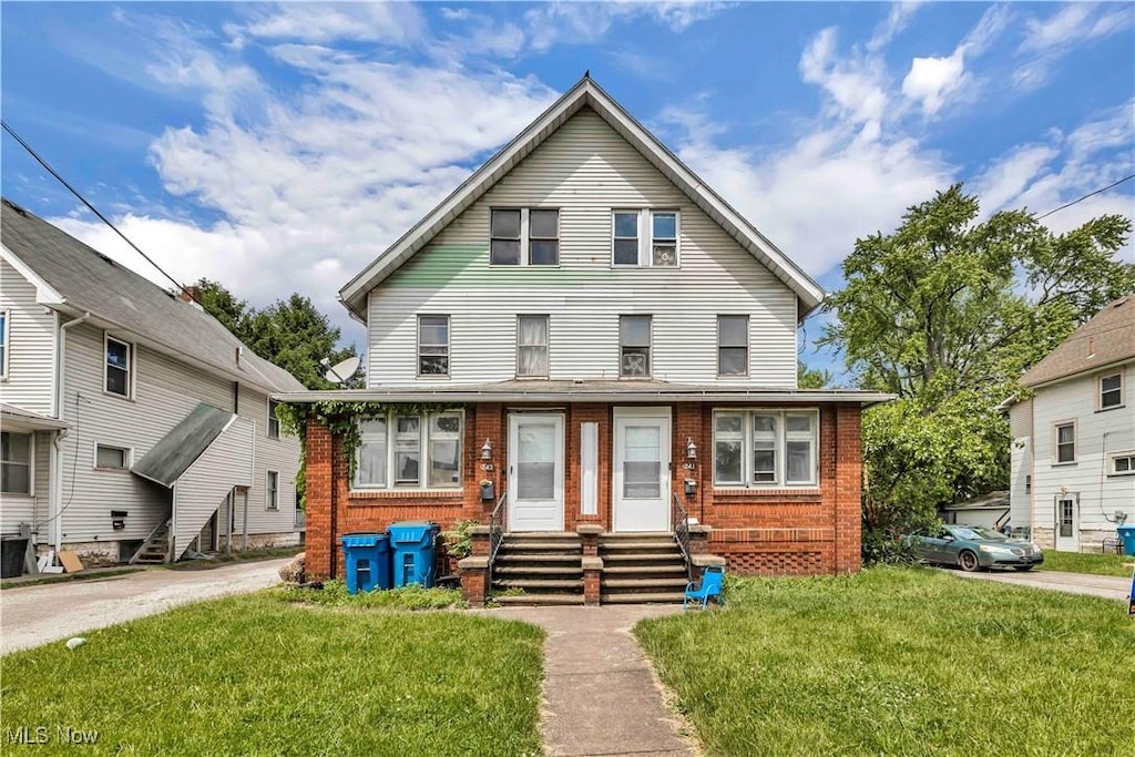 241 Sexton St, Struthers, OH 44471 - view of front of property with entry steps, brick siding, a front lawn, and central AC unit
