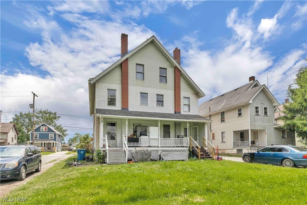 241 Sexton St, Struthers, OH 44471 - view of front of house featuring a porch, a front yard, and a chimney