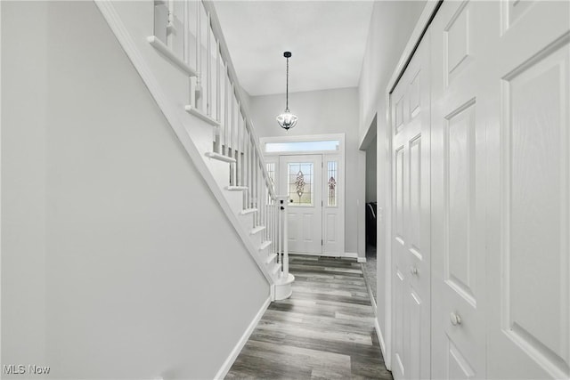 301 Tower Ln, Amherst, OH 44001 - entryway featuring baseboards, dark wood-style flooring, stairway, and a chandelier