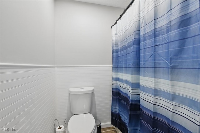 301 Tower Ln, Amherst, OH 44001 - full bathroom with toilet, a wainscoted wall, and a shower with curtain