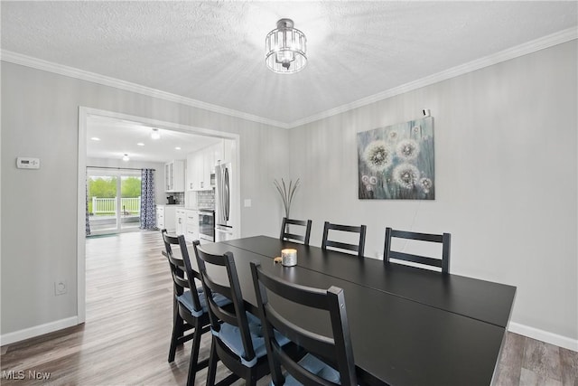 301 Tower Ln, Amherst, OH 44001 - dining space featuring wood finished floors, a chandelier, baseboards, ornamental molding, and a textured ceiling