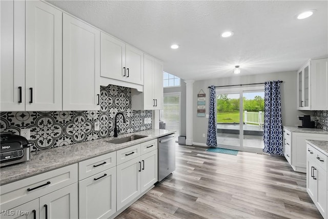 301 Tower Ln, Amherst, OH 44001 - kitchen with dishwasher, a sink, tasteful backsplash, white cabinetry, and baseboards