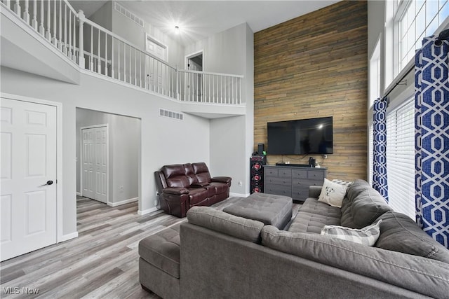 301 Tower Ln, Amherst, OH 44001 - living area with a towering ceiling, wood finished floors, baseboards, and wood walls