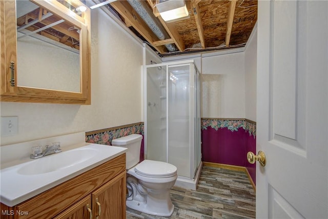 301 Tower Ln, Amherst, OH 44001 - full bathroom with toilet, vanity, a stall shower, and wood finished floors