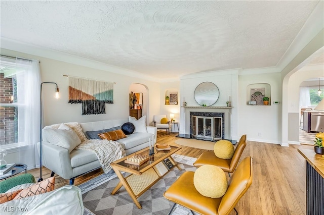 2546 Atlantic, Warren, OH 44483 - living room with arched walkways, a textured ceiling, light wood-style flooring, a glass covered fireplace, and baseboards