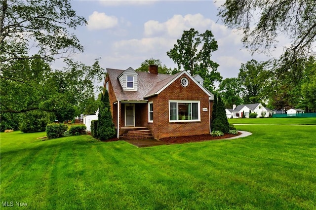 2546 Atlantic, Warren, OH 44483 - view of front of home featuring brick siding, a front yard, and a chimney