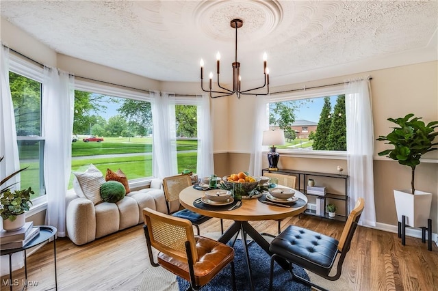 2546 Atlantic, Warren, OH 44483 - dining room with a chandelier, a textured ceiling, light wood finished floors, and baseboards