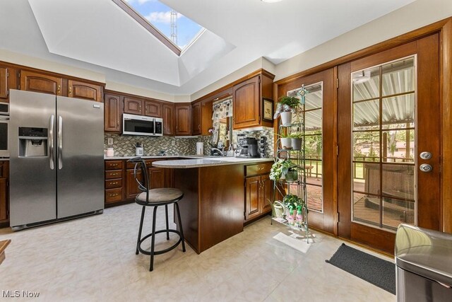 1033 Briarcliff Ave, Alliance, OH 44601 - kitchen with appliances with stainless steel finishes, a skylight, plenty of natural light, and decorative backsplash