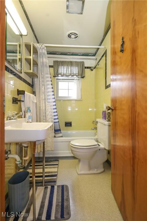 58429 Lashley Rd, Senecaville, OH 43780 - bathroom featuring toilet, shower / bath combo, tile walls, and a sink