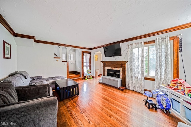 3906 Redfern Rd, Parma, OH 44134 - living area featuring a glass covered fireplace, crown molding, wood finished floors, and baseboards