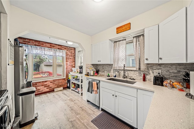 3906 Redfern Rd, Parma, OH 44134 - kitchen with appliances with stainless steel finishes, a sink, healthy amount of natural light, decorative backsplash, and brick wall