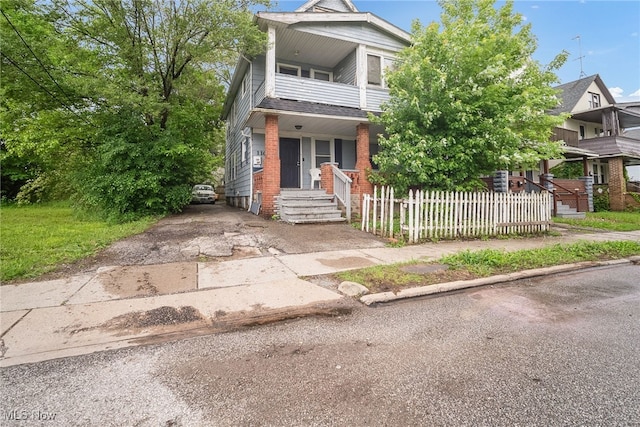 11020 Woodstock Ave, Cleveland, OH 44104 - townhome / multi-family property featuring a porch, a balcony, brick siding, and driveway