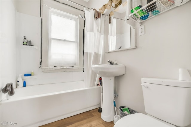 11020 Woodstock Ave, Cleveland, OH 44104 - bathroom featuring toilet, shower / bath combination with curtain, wood finished floors, and a sink