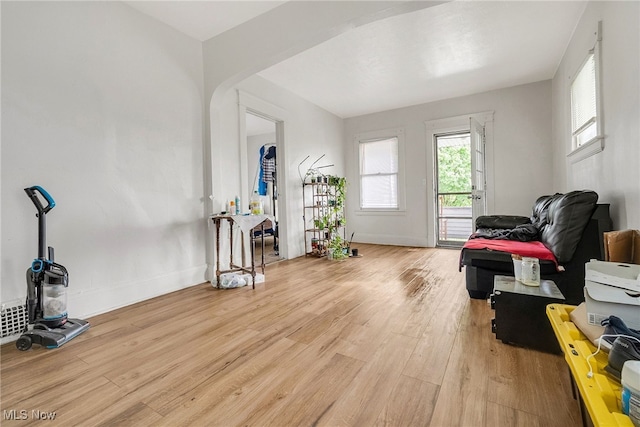 11020 Woodstock Ave, Cleveland, OH 44104 - living area with wood finished floors, arched walkways, a wood stove, and baseboards