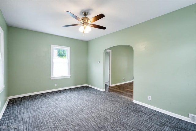 321 Cornell Ave, Youngstown, OH 44507 - unfurnished room with arched walkways, dark carpet, a ceiling fan, and baseboards