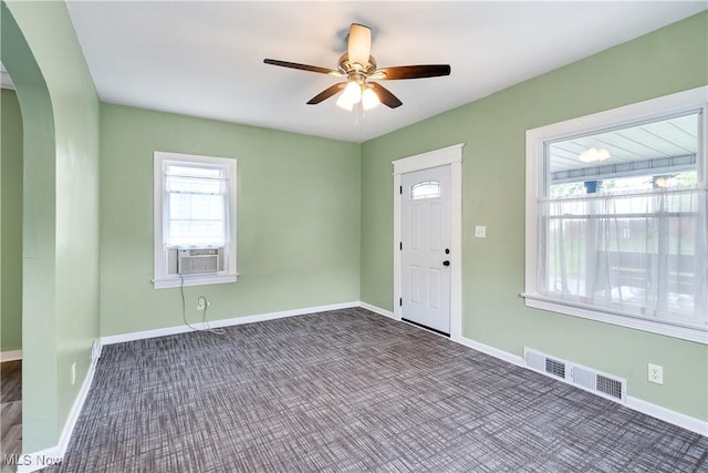 321 Cornell Ave, Youngstown, OH 44507 - foyer with arched walkways, dark colored carpet, ceiling fan, cooling unit, and baseboards