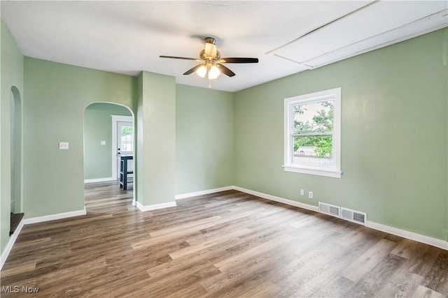 321 Cornell Ave, Youngstown, OH 44507 - unfurnished room featuring arched walkways, a ceiling fan, wood finished floors, and baseboards