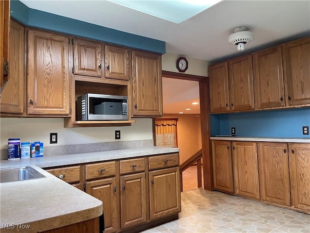 29000 Norman Ave, Wickliffe, OH 44092 - kitchen featuring stainless steel microwave, brown cabinetry, light countertops, and a sink