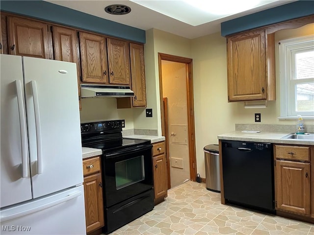29000 Norman Ave, Wickliffe, OH 44092 - kitchen featuring black appliances, under cabinet range hood, light countertops, brown cabinets, and a sink
