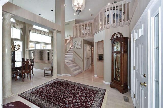 3691 Lexington Ct, Westlake, OH 44145 - entryway featuring a chandelier, ornate columns, a towering ceiling, stairs, and baseboards