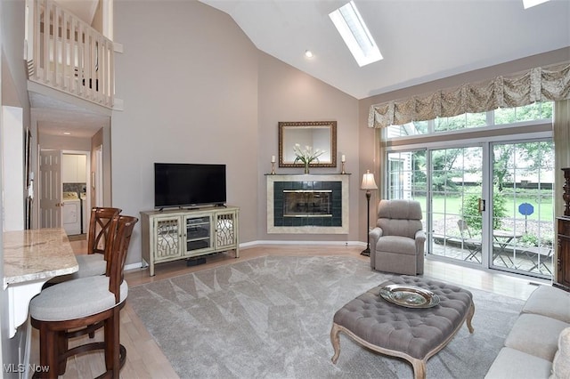 3691 Lexington Ct, Westlake, OH 44145 - living area featuring high vaulted ceiling, a skylight, a tile fireplace, wood finished floors, and baseboards