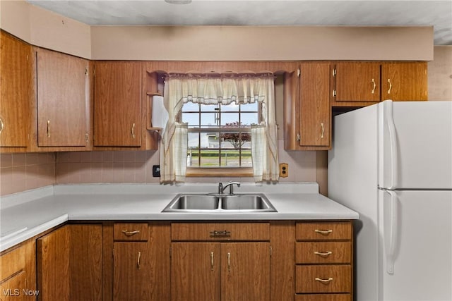 68951 Pine Terrace Rd, Bridgeport, OH 43912 - kitchen with freestanding refrigerator, a sink, brown cabinets, and light countertops