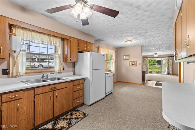68951 Pine Terrace Rd, Bridgeport, OH 43912 - kitchen featuring a sink, white appliances, light countertops, brown cabinets, and baseboards