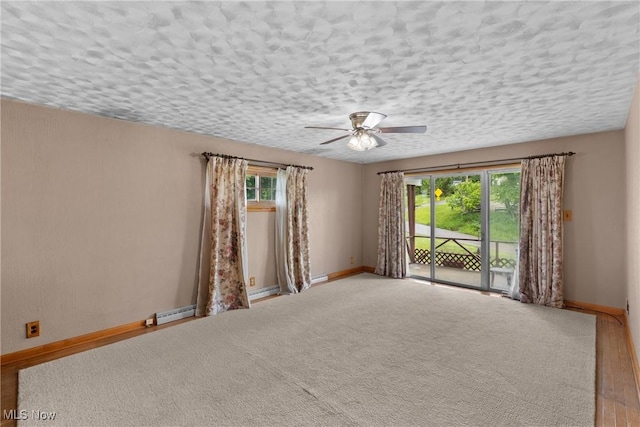 68951 Pine Terrace Rd, Bridgeport, OH 43912 - spare room featuring ceiling fan, baseboards, a textured ceiling, baseboard heating, and wood finished floors