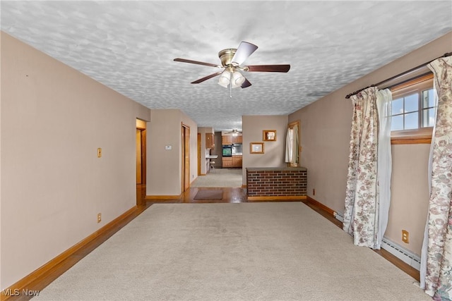 68951 Pine Terrace Rd, Bridgeport, OH 43912 - unfurnished living room featuring a ceiling fan, a textured ceiling, baseboards, and a baseboard heating unit
