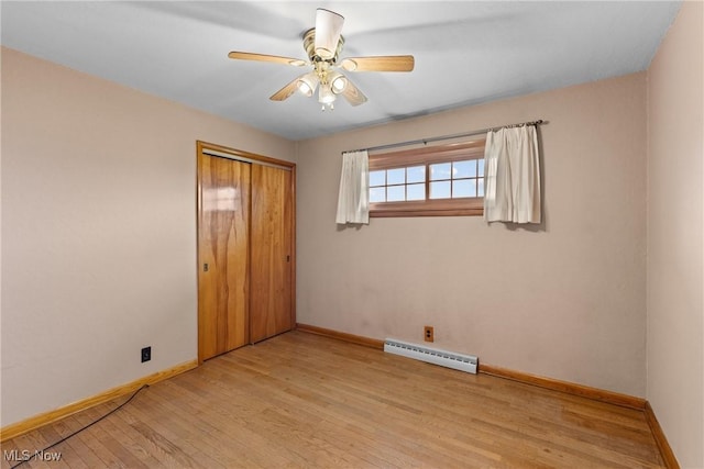 68951 Pine Terrace Rd, Bridgeport, OH 43912 - unfurnished bedroom with baseboard heating, baseboards, light wood-type flooring, a closet, and ceiling fan