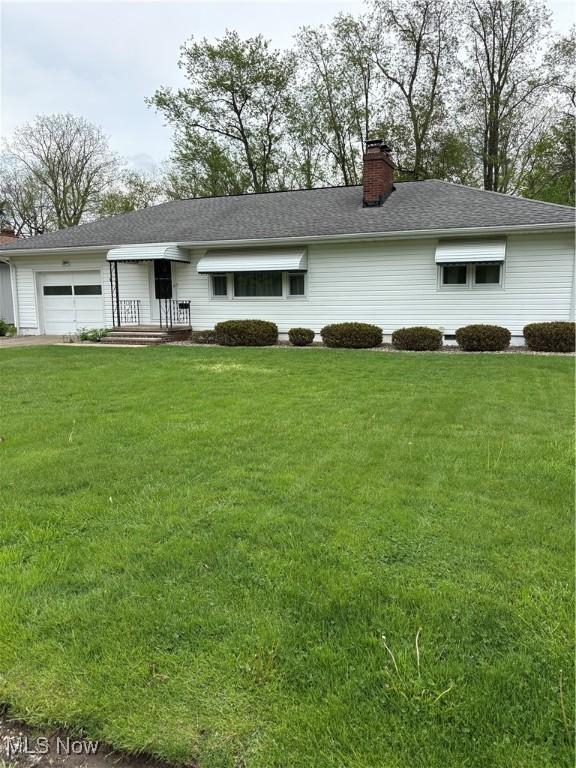 2499 Nesmith Lake Blvd, Akron, OH 44314 - single story home with an attached garage, a front lawn, and a chimney