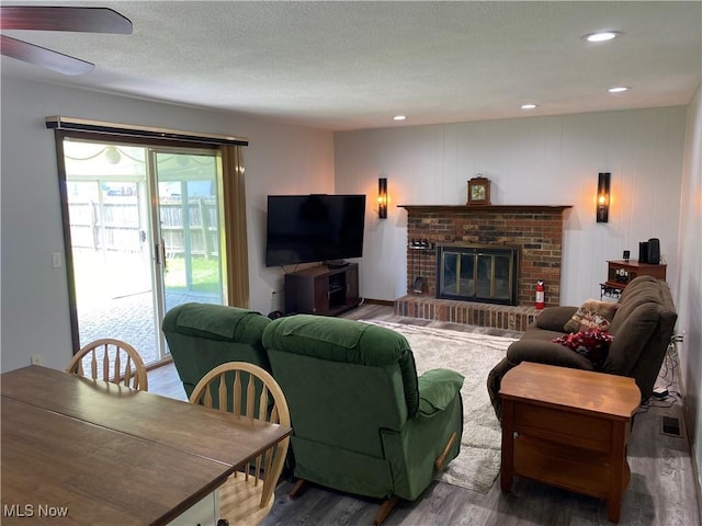 2733 W 37th St, Lorain, OH 44053 - living room featuring wood finished floors, a fireplace, a textured ceiling, recessed lighting, and ceiling fan