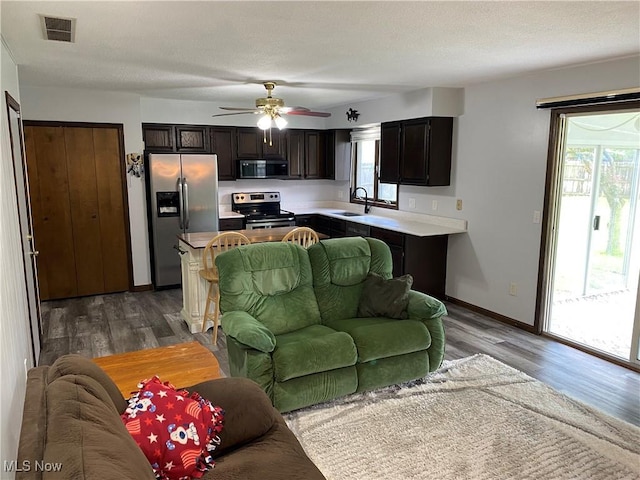 2733 W 37th St, Lorain, OH 44053 - living area with wood finished floors, baseboards, a ceiling fan, and a textured ceiling