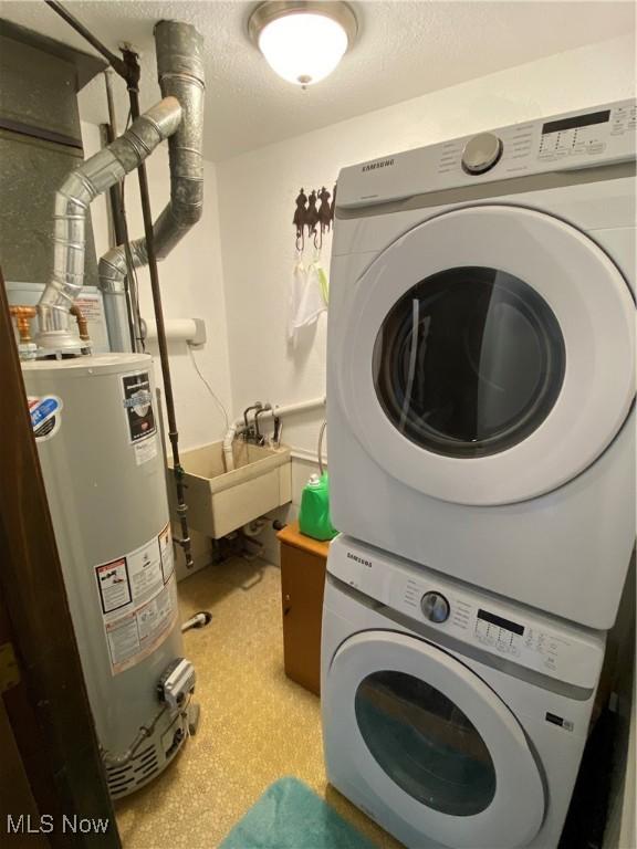 2733 W 37th St, Lorain, OH 44053 - washroom featuring stacked washer / dryer, gas water heater, and a textured ceiling