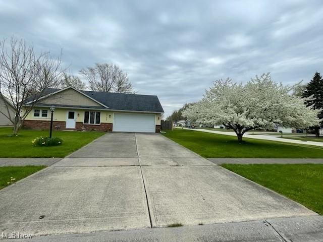 2733 W 37th St, Lorain, OH 44053 - ranch-style home featuring a garage, concrete driveway, and a front yard