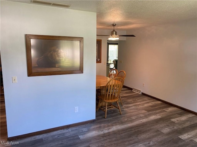 2733 W 37th St, Lorain, OH 44053 - dining room with dark wood finished floors, a ceiling fan, baseboards, and a textured ceiling