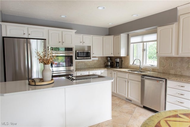 30907 Arlington Cir, Bay Village, OH 44140 - kitchen featuring appliances with stainless steel finishes, a sink, white cabinets, tasteful backsplash, and light tile patterned floors