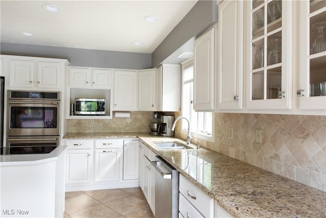 30907 Arlington Cir, Bay Village, OH 44140 - kitchen with a sink, appliances with stainless steel finishes, glass insert cabinets, white cabinetry, and recessed lighting