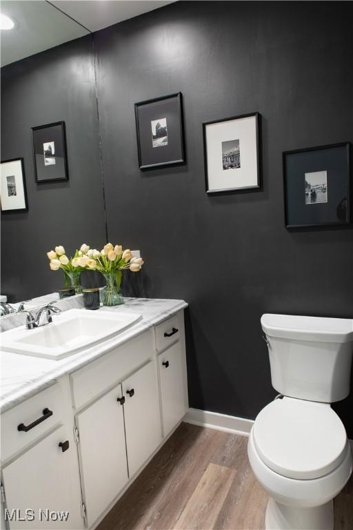 30907 Arlington Cir, Bay Village, OH 44140 - half bathroom with vanity, wood finished floors, toilet, and baseboards
