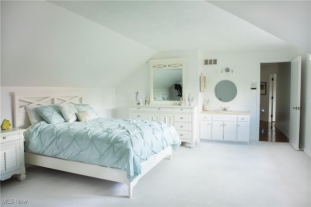 30907 Arlington Cir, Bay Village, OH 44140 - bedroom with vaulted ceiling, light carpet, a sink, and ensuite bath