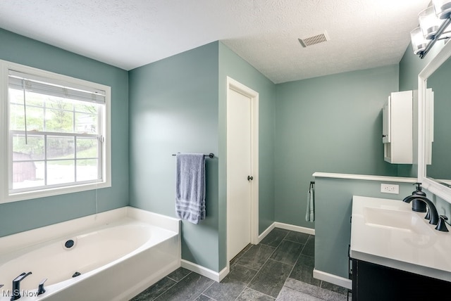 2042 Summer Evening Dr, Canal Fulton, OH 44614 - bathroom with double vanity, a bath, baseboards, and a textured ceiling