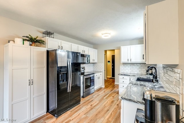 2042 Summer Evening Dr, Canal Fulton, OH 44614 - kitchen featuring black appliances, a sink, dark stone counters, white cabinetry, and light wood-style flooring