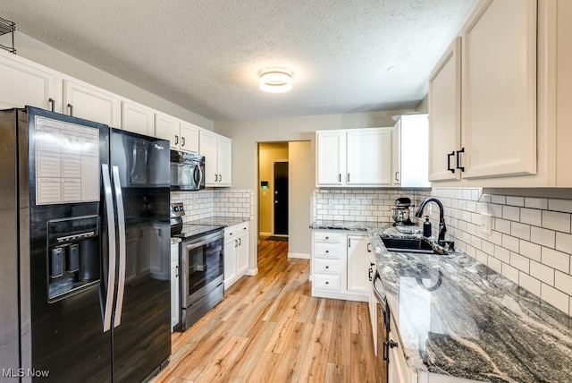 2042 Summer Evening Dr, Canal Fulton, OH 44614 - kitchen featuring black appliances, a sink, light wood-type flooring, stone counters, and a textured ceiling