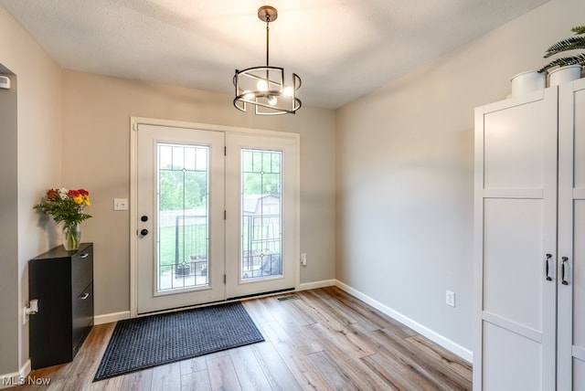 2042 Summer Evening Dr, Canal Fulton, OH 44614 - doorway with light wood-style floors, a chandelier, and baseboards
