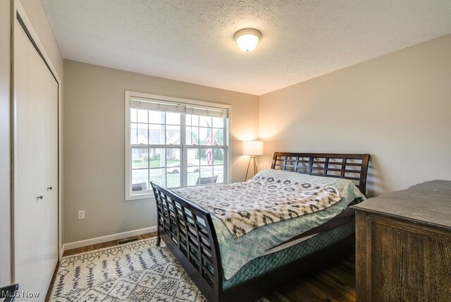 2042 Summer Evening Dr, Canal Fulton, OH 44614 - bedroom featuring wood finished floors, baseboards, a closet, and a textured ceiling