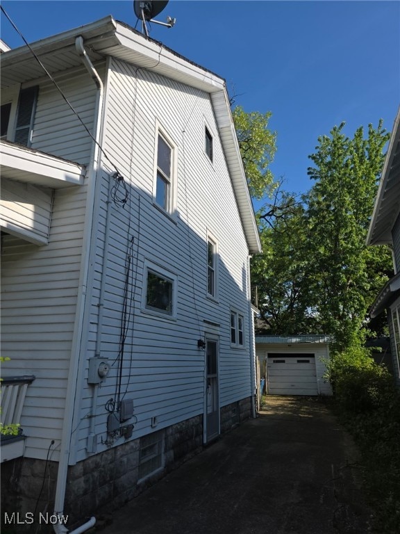 1119 W 11th St, Lorain, OH 44052 - view of home's exterior featuring an outdoor structure and asphalt driveway