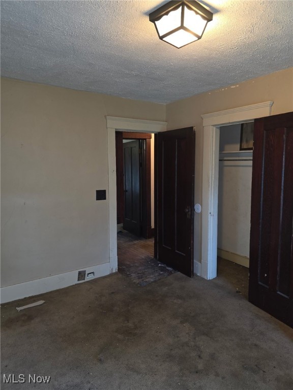 1119 W 11th St, Lorain, OH 44052 - unfurnished bedroom featuring carpet, a textured ceiling, and baseboards