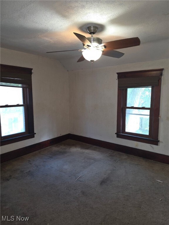 1119 W 11th St, Lorain, OH 44052 - carpeted spare room with healthy amount of natural light, a ceiling fan, baseboards, and a textured ceiling