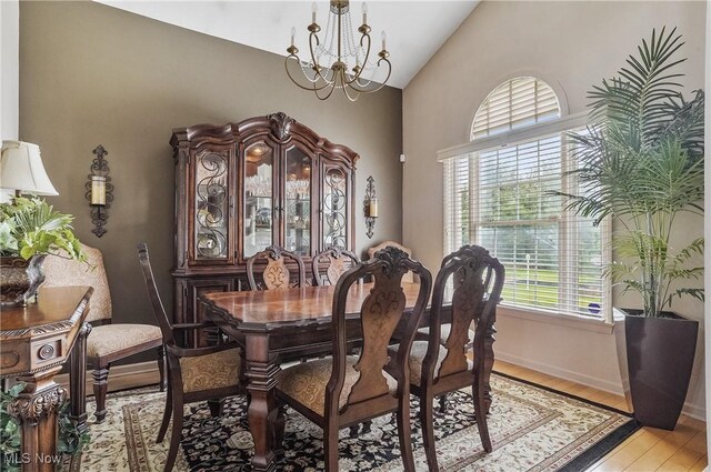 8550 Ivy Hill Dr Unit 16, Poland, OH 44514 - dining space with a chandelier, vaulted ceiling, light wood-style floors, and baseboards